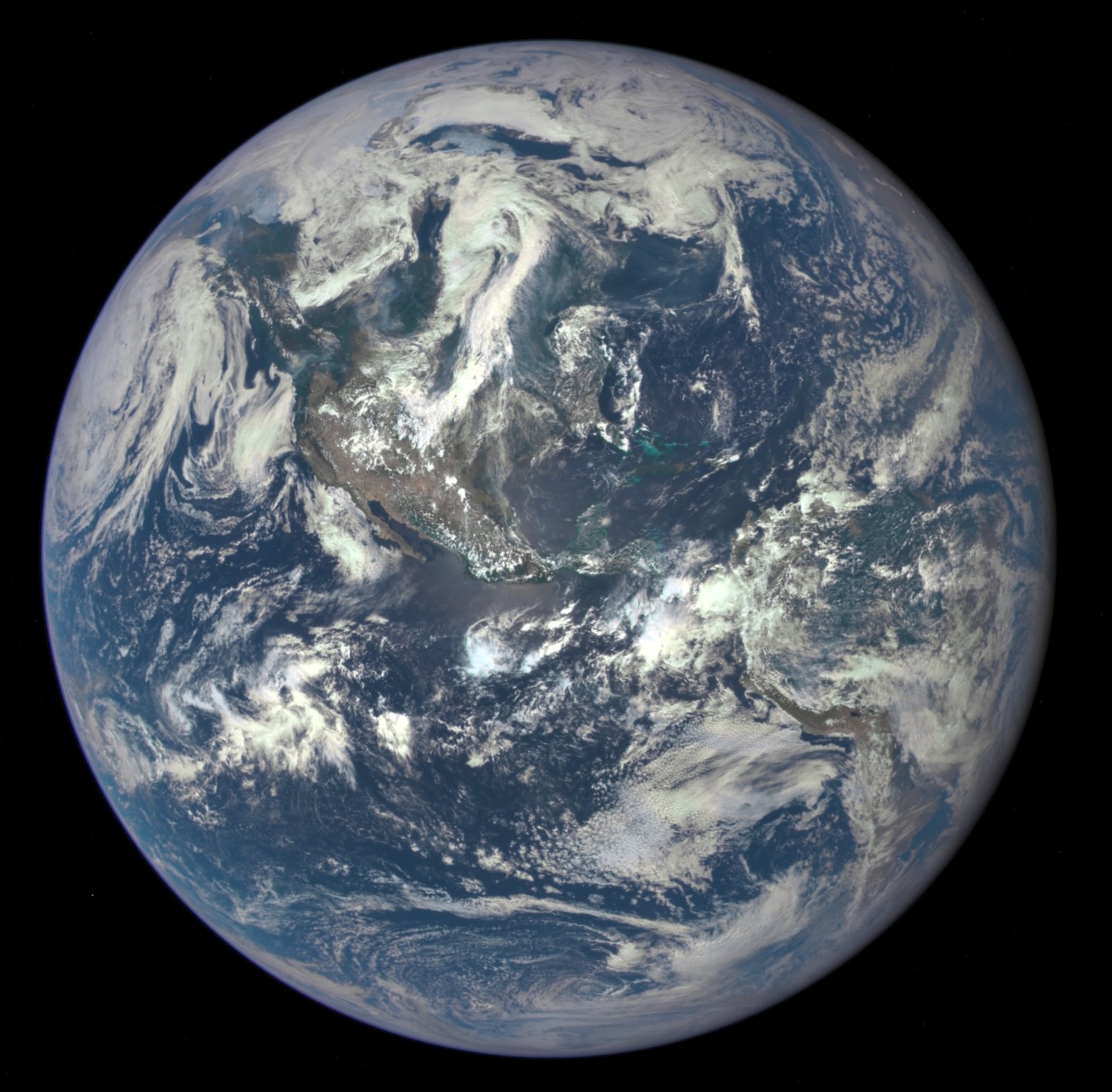 The whole round Earth seen from far away: blue oceans, white swirls of cloud and the brown and green of North America.